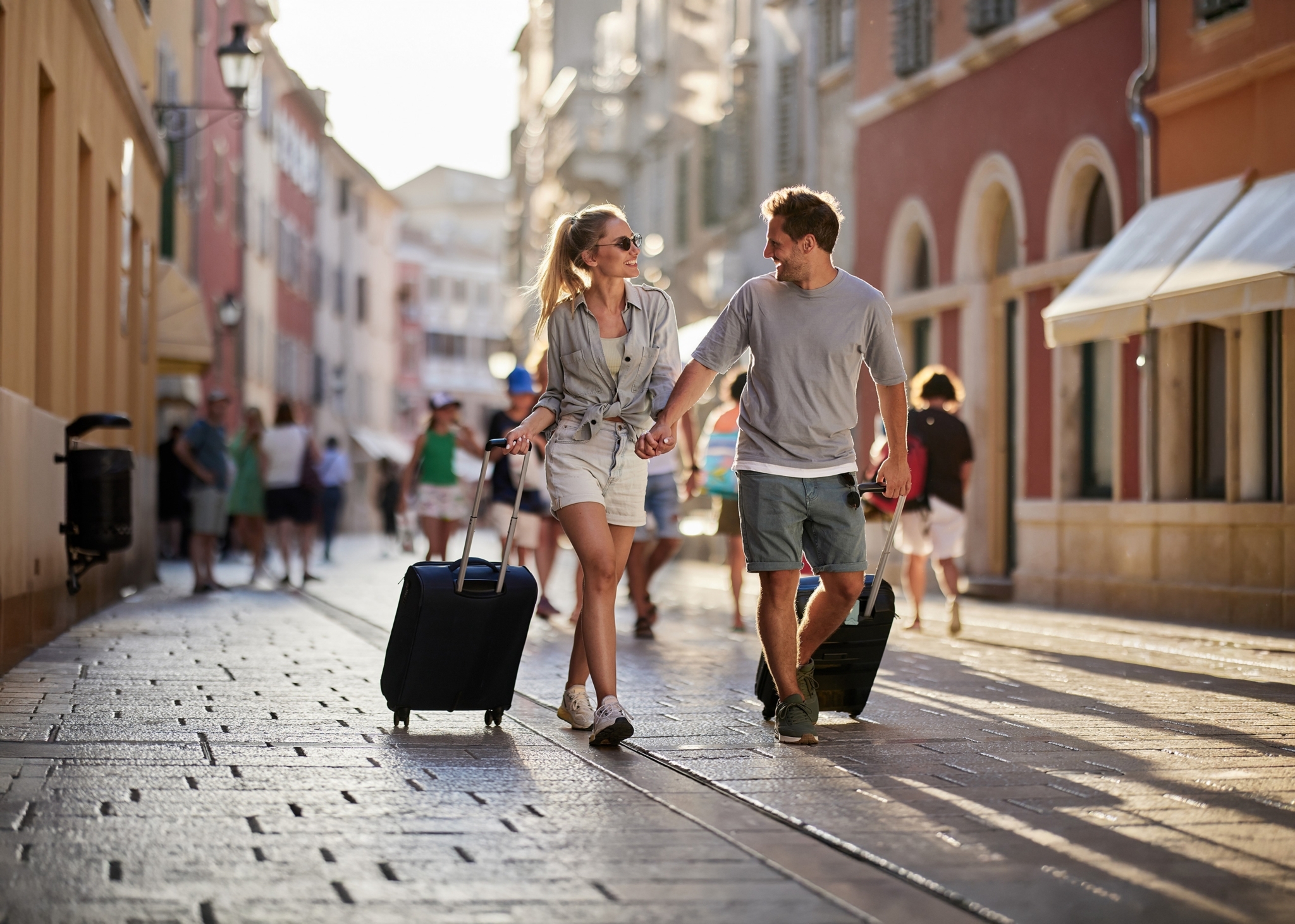A couple on vacation walking with their luggage