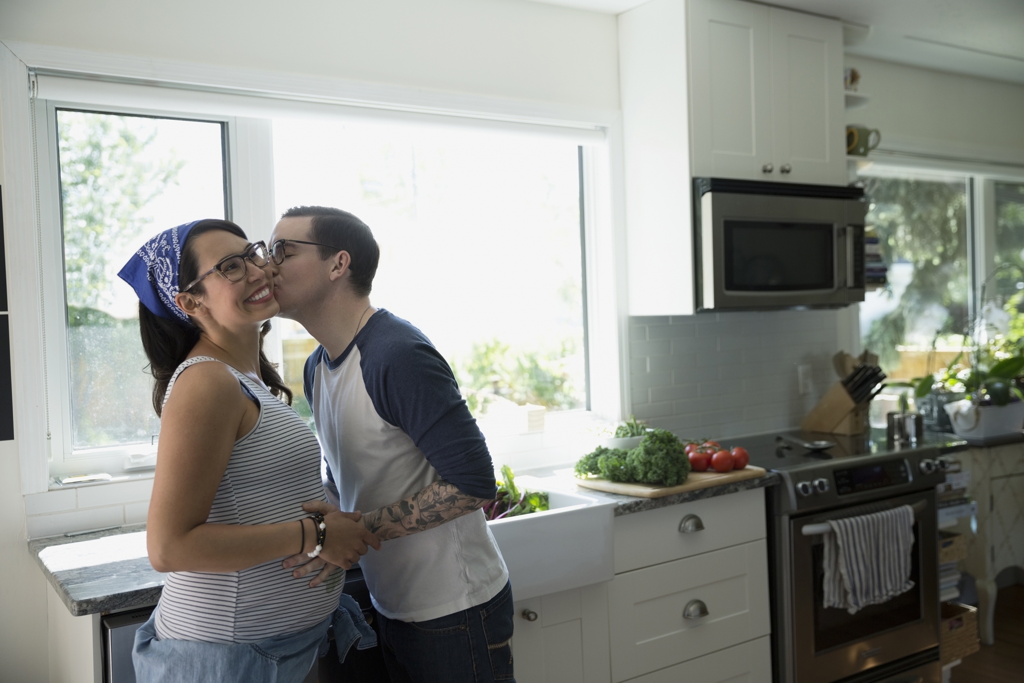 Pregnant Couple Kissing in Kitchen
