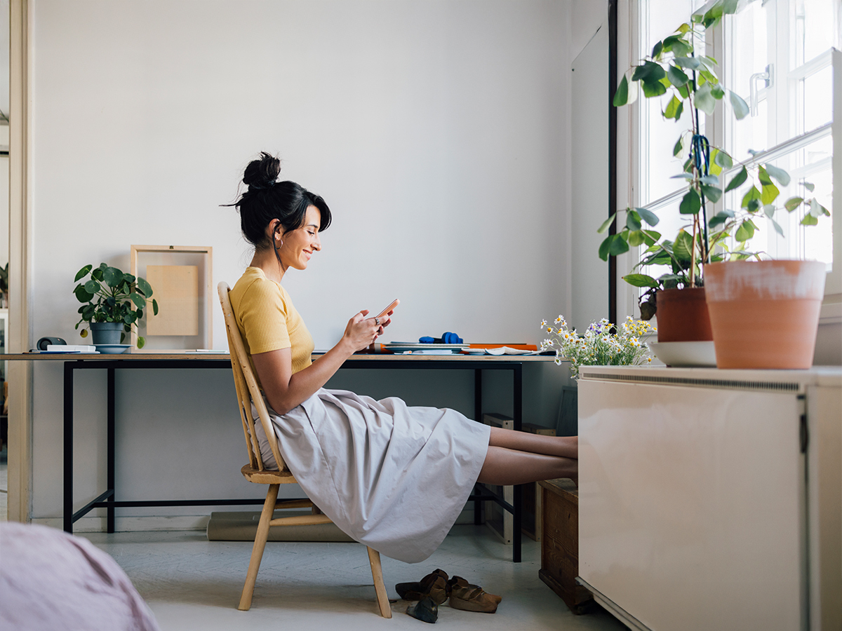 Woman at desk looking at her phone