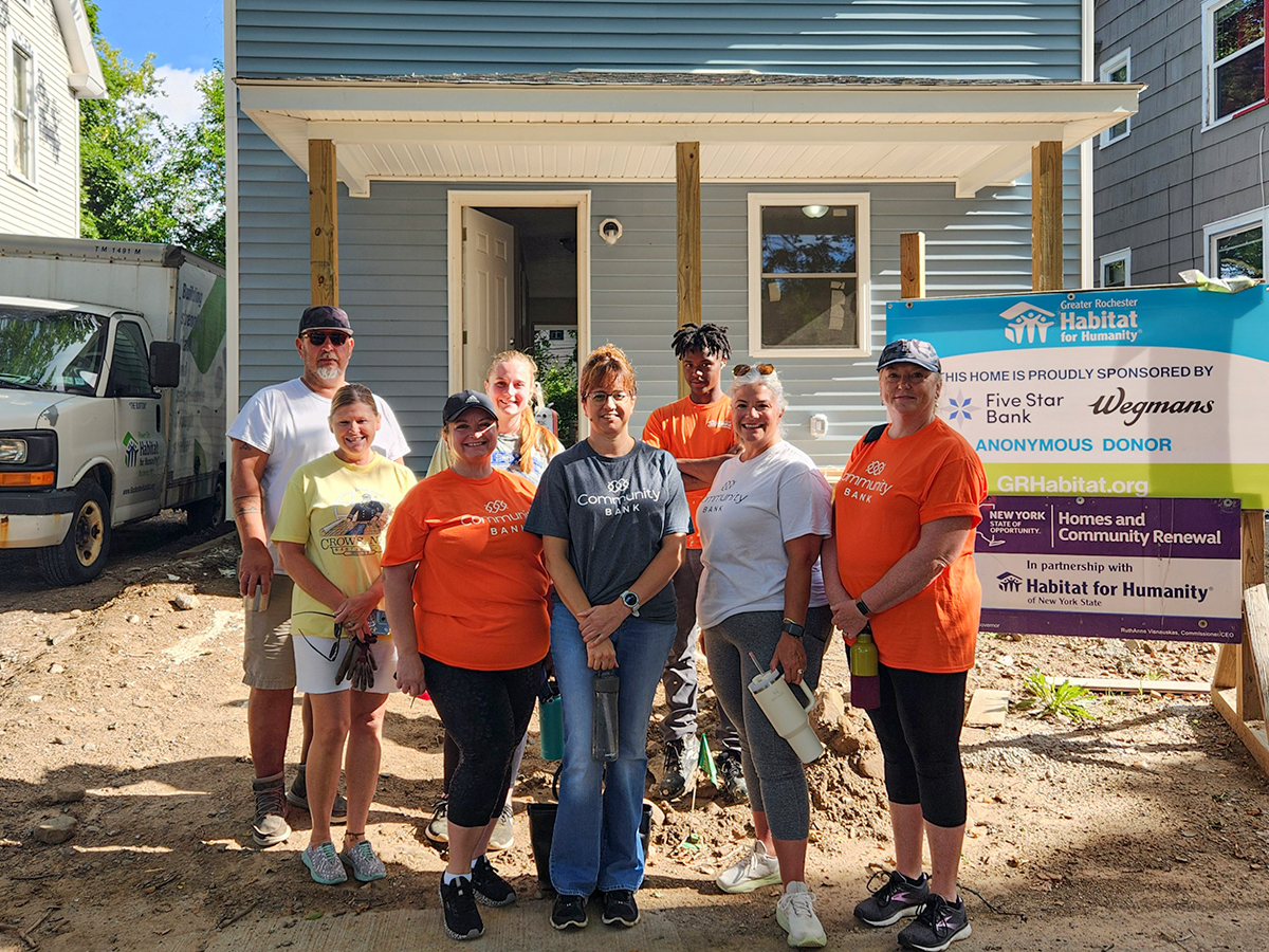 CBNA Volunteers standing in front of an under-construction home