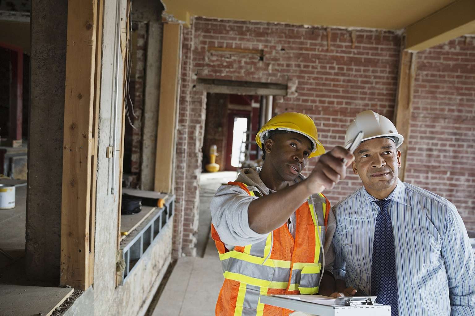 Two Men Speaking at Construction Site