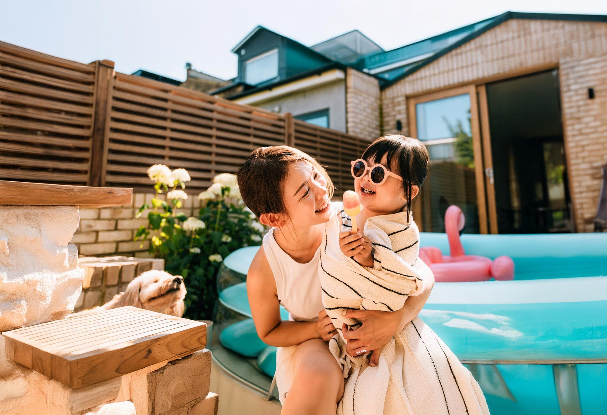 Woman and child playing outside by the pool