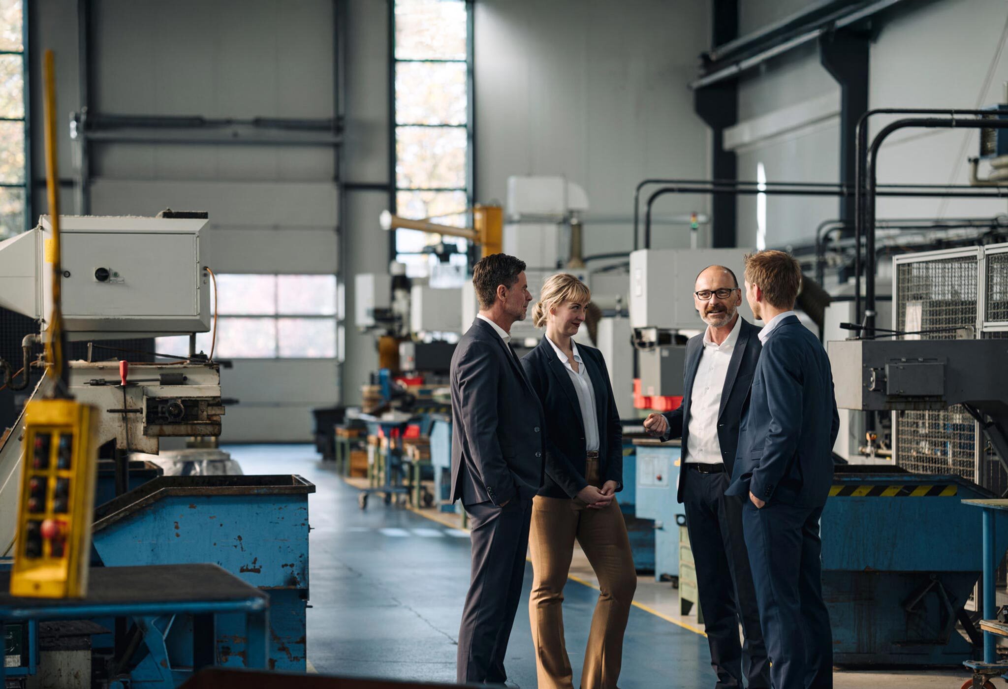 Business people standing in machine shop