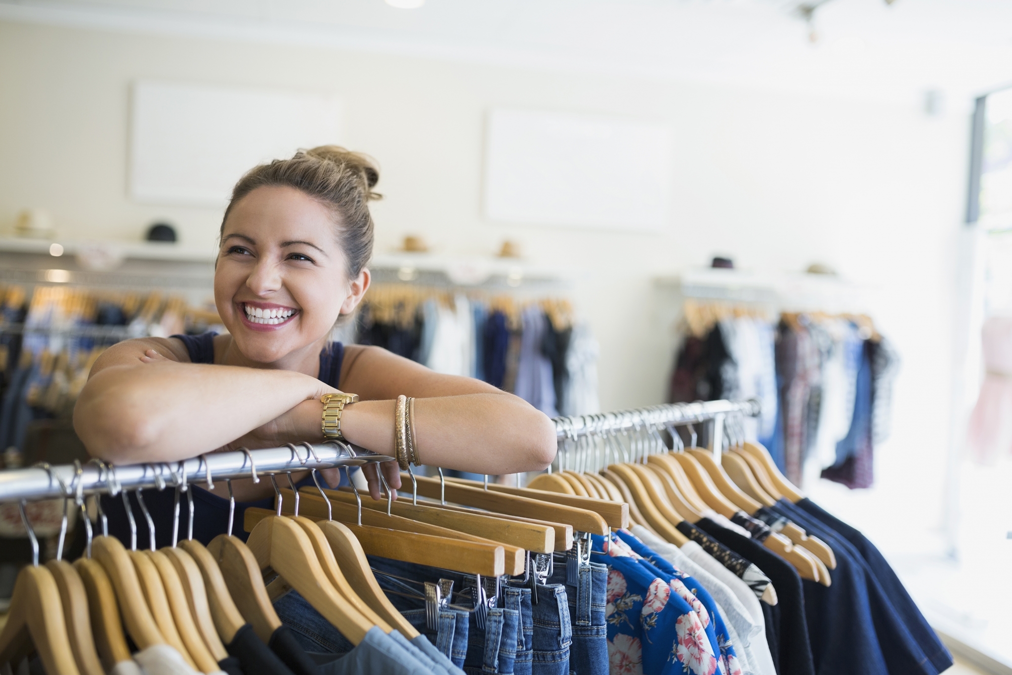 Woman Smiling Over Clothes Rack