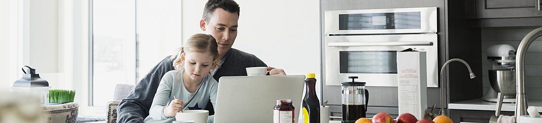 Father Drinking Coffee While Looking at Computer With Daughter