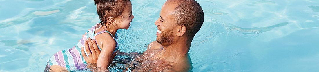 Father Holding Daughter in Pool
